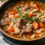 Hearty Beef Barley Soup with tender beef, plump barley, and vibrant vegetables in a rich, savory broth, garnished with fresh parsley.