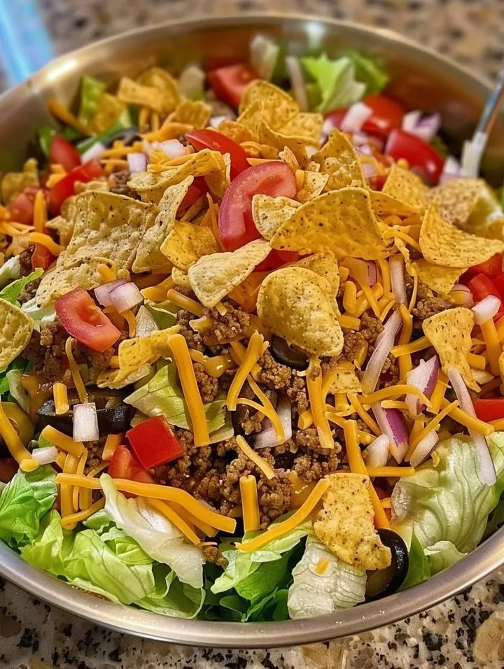crunchy Dorito Taco Salad recipe combining seasoned beef, fresh veggies, and cheesy Dorito chips. Perfect for parties and customizable for everyone